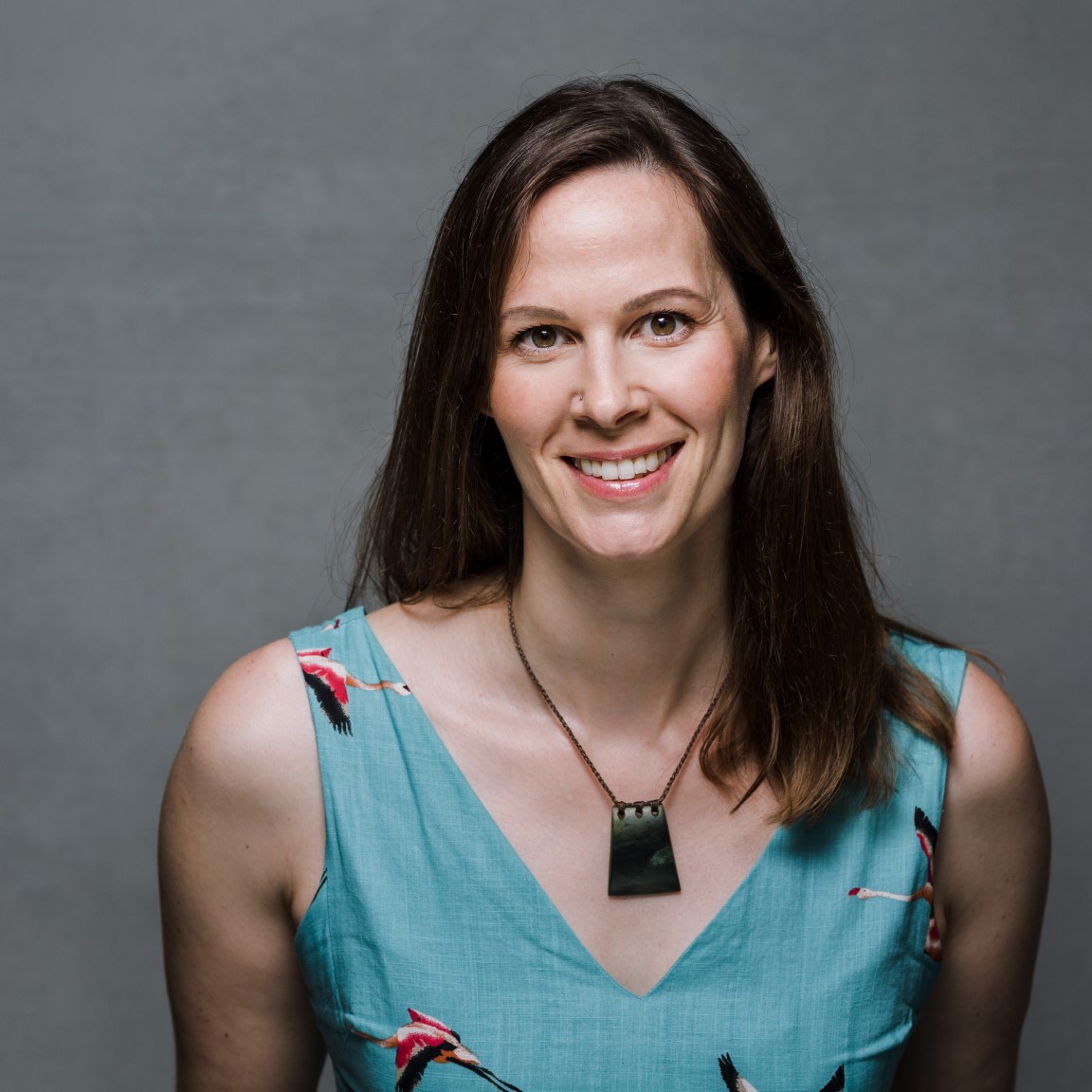 Freelance science communicator Laura Hikawai-Goodall - smiling to camera in blue top with long brown hair